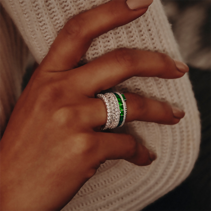 Model wearing Layered AMBER - Emerald Cut Eternity Band in silver with clear gems, stacked with other rings
