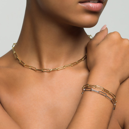Model wearing Layered JUSTINE Paperclip Chain in gold with two JUSTINE Paperclip Bracelets in silver and gold